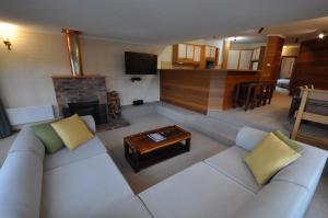 a living room with a white couch and a fireplace at Salzburg Apartments in Perisher Valley
