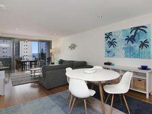 ein Wohnzimmer mit einem weißen Tisch und Stühlen in der Unterkunft Eden Apartments Unit 502 in Gold Coast