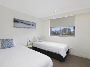 ein Schlafzimmer mit zwei Betten und einem Fenster in der Unterkunft Eden Apartments Unit 502 in Gold Coast + 13 Fotos