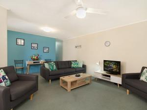 - un salon avec deux canapés et une télévision dans l'établissement Kingston Court Unit 11, à Gold Coast