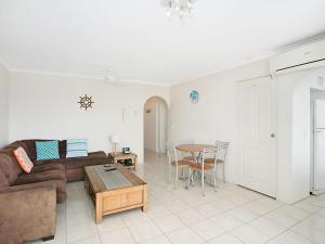 een woonkamer met een bank en een tafel bij Kirra Gardens Unit 30 in Gold Coast