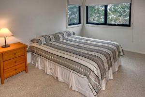 a bedroom with a bed with a nightstand and a window at Delmonte in Medlow Bath