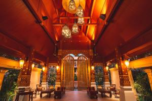 an ornate building with a large gate and tables and chairs at Burasari Phuket Resort & Spa - SHA Extra Plus in Patong Beach