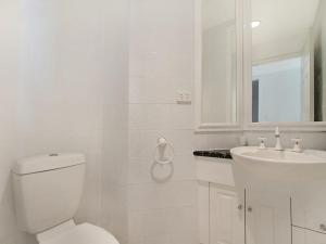 a white bathroom with a toilet and a sink at Orion Unit 7 in Gold Coast