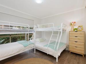 黃金海岸的住宿－Tahnee Court Unit 3，一间带两张双层床和梳妆台的卧室