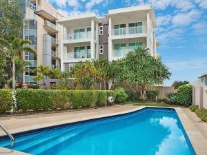 een gebouw met een zwembad voor een gebouw bij Solaya Unit 6 in Gold Coast