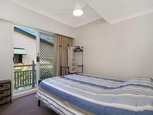 a bedroom with a bed and a balcony at Tondio Terrace Flat 1 in Gold Coast