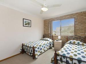 
a bed room with two beds and a window at Tumut Unit 1 - Great unit in a central location to beaches, clubs and shopping in Coolangatta
