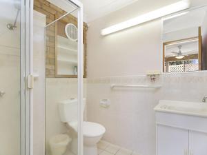
a bathroom with a toilet, sink and mirror at Tumut Unit 1 - Great unit in a central location to beaches, clubs and shopping in Coolangatta
