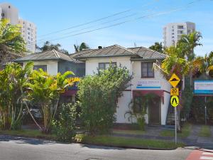 a white house with a street sign in front of it at Tondio Terrace Flat 5 - Pet friendly and close to the beach in Gold Coast