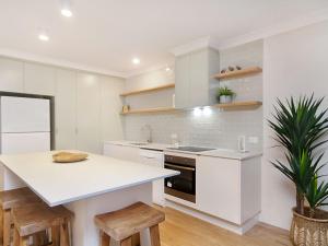 
a kitchen with a stove top oven and a dishwasher at Tumut Unit 2 - Great unit in a central location to beaches, clubs and shopping Wi-Fi included in Coolangatta
