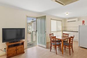 a dining room with a table and a television at Discovery Parks - Roxby Downs in Roxby Downs
