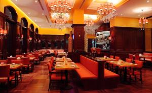 un restaurante con mesas, sillas y lámparas de araña en Maritim Hotel Changzhou, en Changzhou