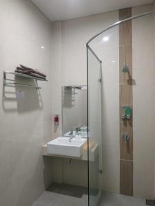 a bathroom with a sink and a glass shower at Choice City Hotel in Surabaya