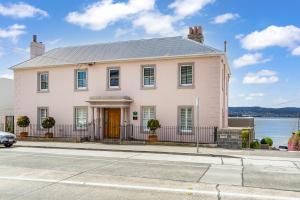 a white house on a street with a body of water at Maison del Mar in Hobart