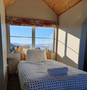 a bed in a room with a large window at Aorangi House in Lake Tekapo