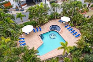 una vista aérea de una piscina con sillas y sombrillas en Aegean Resort Apartments, en Gold Coast