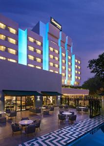 um hotel com mesas e cadeiras em frente a um edifício em The Connaught, New Delhi- IHCL SeleQtions em Nova Deli