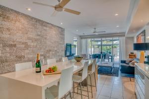 een keuken en eetkamer met een tafel en stoelen bij Coconut Grove in Port Douglas