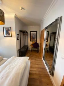 a bedroom with a mirror and a bed and a living room at Hotel Hagspihl in Quakenbrück