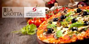 
a pizza sitting on top of a wooden table at Al Khaleej Palace Deira Hotel in Dubai
