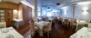 a restaurant with white tables and chairs in a room at Hotel Los Conejos in Mora