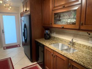 a kitchen with a sink and a refrigerator at Island House Beach Resort 10S in Point O'Rocks