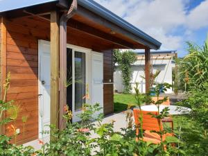 een klein houten huisje met een deur en een patio bij Les Coeurs d'Amants in Saint-Joseph