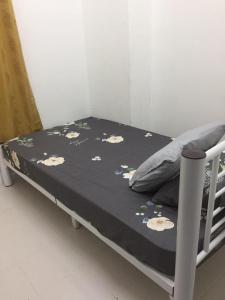 a bed with a black blanket with flowers on it at Cinnamon Sutravilla Unit No D3A6 Lift Level 4, Sutravilla 2 in Kuantan