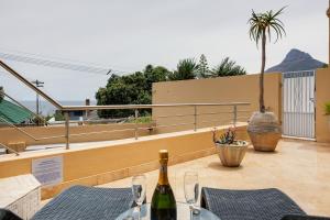 a bottle of wine sitting on top of a patio at Backup-Powered Camps Bay Beach Condo in Cape Town +22 photos