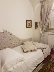 una camera da letto con un letto bianco e fiori sul muro di 20 Passi dal Duomo a Firenze