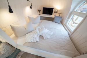 een wit bed met twee witte handdoeken erop bij Panorama Iglu Romantik & Family in Parey