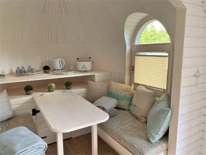 um quarto com uma mesa e um banco numa pequena casa em Panorama Iglu Romantik & Family em Parey