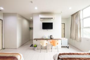 a bedroom with a table and two chairs in it at BG Business Hotel in Bukit Mertajam