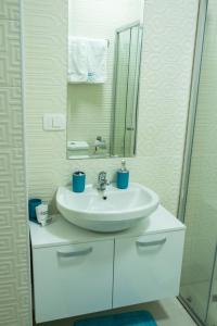 a bathroom with a white sink and a mirror at Apartments Dudanovski in Ohrid