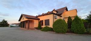 dom z samochodem zaparkowanym przed nim w obiekcie Zajazd Motel Staropolski w mieście Pyskowice