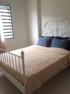 a white bed with blue pillows in a bedroom at Cinnamon Sutravilla Unit No D3A6 Lift Level 4, Sutravilla 2 in Kuantan