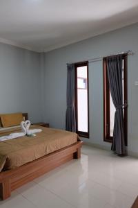een slaapkamer met een bed en een groot raam bij Prada Apartment in Seminyak