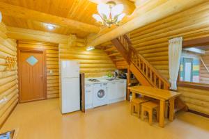 a kitchen with a refrigerator and a table in a log cabin at Jungmun Log Pension & Resort in Seogwipo