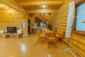 a dining room with a table and chairs in a log cabin at Jungmun Log Pension & Resort in Seogwipo