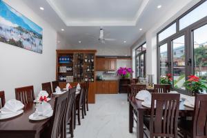 a dining room with wooden tables and chairs and windows at Airport Classic Hotel & Travel in Hanoi