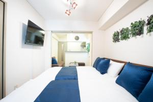 une chambre avec un grand lit avec des oreillers bleus dans l'établissement Elizabeth Garden II, à Osaka