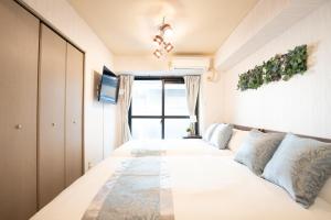 une chambre avec deux lits et une fenêtre dans l'établissement Elizabeth Garden II, à Osaka