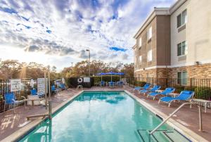 a swimming pool with chairs and a building at Holiday Inn Express Hotel & Suites Roseville - Galleria Area by IHG in Roseville