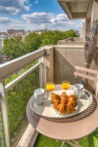 un tavolo con un piatto di croissant sul balcone di 825 - Panoramic view in Paris Olympic Games 2024 a Parigi