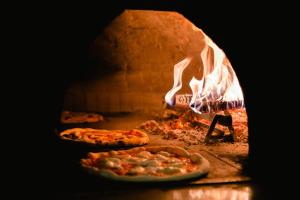 um forno de pizza com duas pizzas dentro em Le Lanterne em Borgo San Dalmazzo