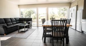 a kitchen and living room with a table and chairs at Saxnäs Ferieboende L Sara in Färjestaden +8 photos