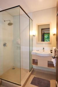 La salle de bains est pourvue d'une douche en verre et d'un lavabo. dans l'établissement D'Agape Meeting & Conference, à Puncak