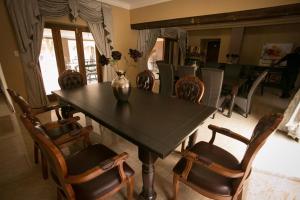 a dining room with a black table and chairs at Ein Gedi Premier Weddings And Conferences in Kimberley