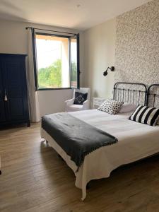 a bedroom with a large bed and a window at Domaine de Sévanes in Saint-Paul-les-Fonts +31 photos